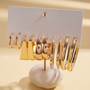 Detailed set of golden geometric earrings featuring round, square and C-shaped metal designs