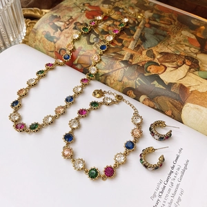 Macro detail of vintage Baroque jewelry set with colorful gems on a classic art book