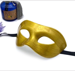 Detail view of a vintage gold brushed half-face mask with elegant black silk ribbons