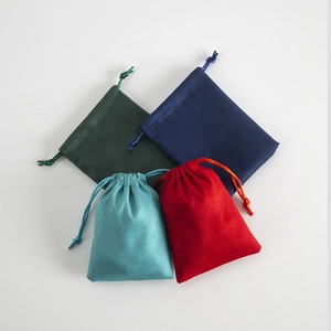 Detailed view of colorful flannel drawstring pouches in red, blue and dark green