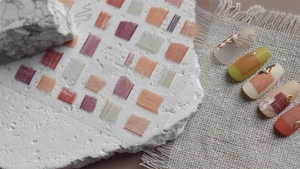 Detailed view of vintage plaid and lace nail stickers in autumn colors on a textured surface