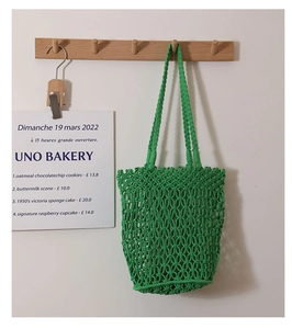 Detail shot of green macrame woven cotton shoulder bag with hollow mesh design