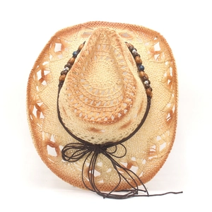 Detail of woven straw cowboy hat with bohemian beads and orange gradient brim
