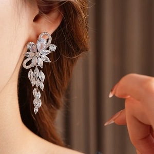Close-up of elegant silver flower tassel earrings with sparkling cubic zirconia on model