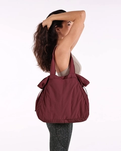 Burgundy water-resistant nylon tote bag shown on a model for yoga and casual sports