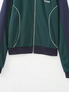 Détail de veste zippée bicolore avec broderie SWTS 1974 et passepoils blancs contrastés