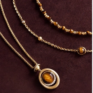 Collana a strati dorata con pendente in occhio di tigre e ciondolo tondo con zirconi