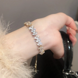 Close-up of green zircon flower bracelet with gold plating on a model's wrist