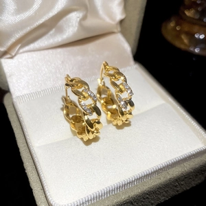 Macro shot of French vintage gold chain earrings with sparkling zircons in a velvet box