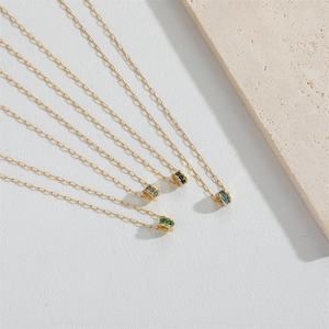 Colliers dorés délicats avec pendentifs anneaux en zircon coloré sur fond texturé
