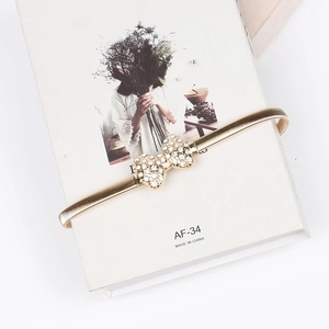 Détail de la ceinture chaîne dorée élastique avec boucle en forme de nœud en strass