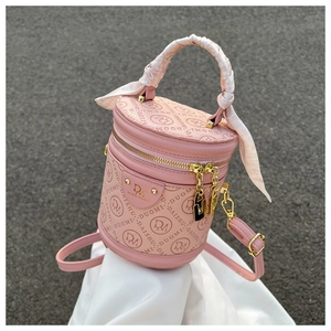 Pink cylinder bucket bag with patterned silk scarf handle and golden hardware detail