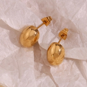 Dettaglio ravvicinato degli orecchini a fagiolo placcati oro 18K su sfondo testurizzato