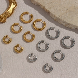 Detailed macro view of minimalist gold and silver hoop earrings in various sizes for women