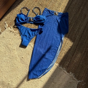 Set bikini blu tre pezzi con fibbie a stella marina e gonna lunga da spiaggia in rete