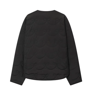 Detail of black quilted jacket featuring intricate bow patterns and wave stitching