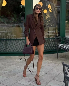 Look urbain du blazer croisé marron coupe longue avec mini-jupe noire et accessoires