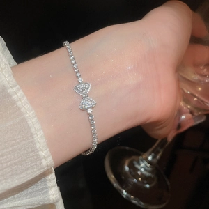 Close-up of elegant silver bowknot tennis bracelet with sparkling zircons on wrist
