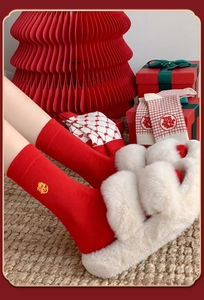 Festive red cotton socks with dragon embroidery and plush slippers in a home holiday setting