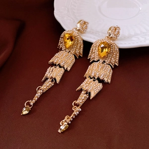 Vue détaillée de boucles d'oreilles vintage dorées avec perles et cristaux en goutte