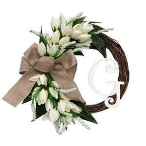 Detail of tulip wreath with woven rattan, burlap bow and white letter G decoration