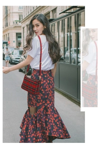 Street style view of a vintage red plaid baguette bag paired with a purple floral skirt