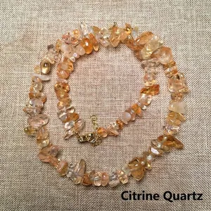 Close-up of irregular natural citrine crystal stone necklace with a gold metal clasp