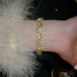 Detailed close-up of oval yellow zircon bracelet with silver S-links on model wrist