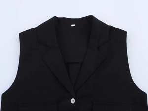 Détail du gilet noir en lin mélangé avec revers crantés et bouton blanc contrastant