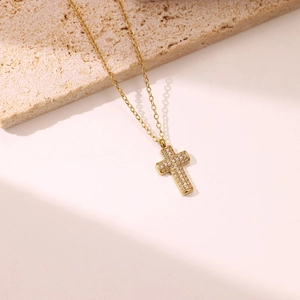 Classic gold cross pendant necklace with micro-paved zircons on a minimalist stone base