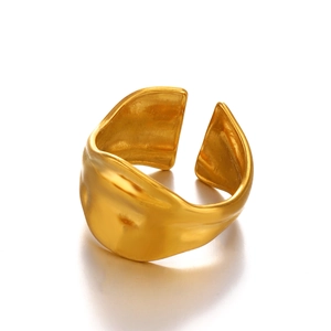 Modern chunky gold plated stainless steel ring with liquid metal texture on white background