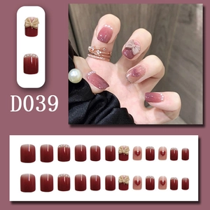 Détails de faux ongles rouge bordeaux avec nœuds 3D, perles et motifs de cœurs