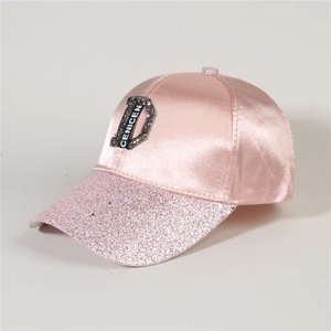 Detail of pink satin baseball cap with sequined brim and decorative letter D patch