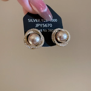 Detail of 925 silver pearl stud earrings with halo diamonds and vintage French elegance
