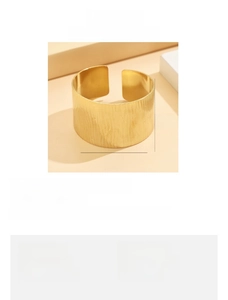 Detailed view of 3.5cm wide gold stainless steel cuff with vertical wave texture