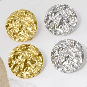 Macro view of gold and silver irregular hammered texture round metal stud earrings