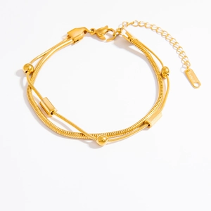 Detail of 18k gold double layer snake chain bracelet with polished beads and S.STEEL tag