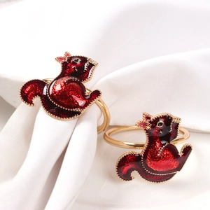Detail of squirrel napkin rings with red glitter enamel and golden beaded edges