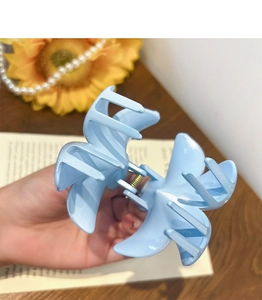 Detail view of light blue butterfly hair claw clip with a glossy plastic finish