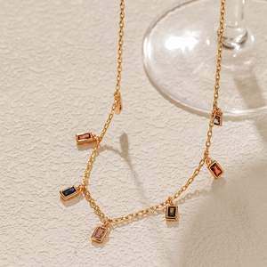 Detail of 18K gold plated chain necklace featuring colorful rectangular cut gemstones