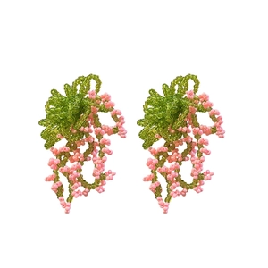 Handmade beaded flower tassel earrings with pink and green seed beads on a white background
