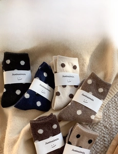 Chaussettes en laine à pois en noir, marron et crème avec étiquettes de marque