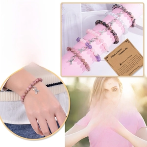Gros plan du bracelet en quartz rose avec breloque ruban rose pour la lutte contre le cancer