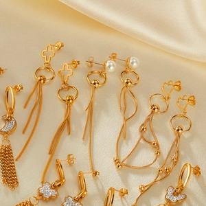 Detail view of gold-plated tassel earrings with pearls and butterflies on silk