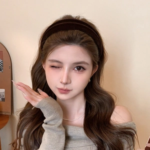 Detailed view of coffee velvet headband on model with elegant cream background
