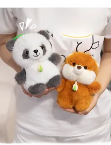 Close-up of cute panda and brown bear plush pendants held in hands with leaf charms