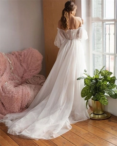 Detail of off-shoulder puff sleeves and delicate polka dot mesh on white wedding gown