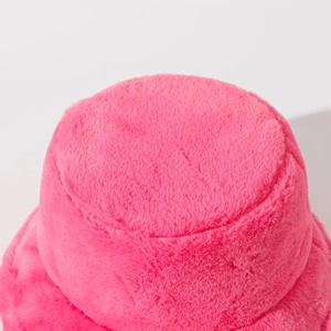 Macro detail of the plush faux fur texture on a bright pink winter bucket hat