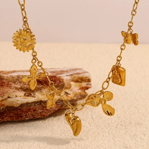 Détail d'un collier plaqué or 18 carats avec trèfle, tournesol, ours et cœur