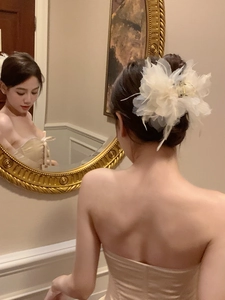 Detail of cream fabric floral hair claw clip used on an elegant updo hairstyle